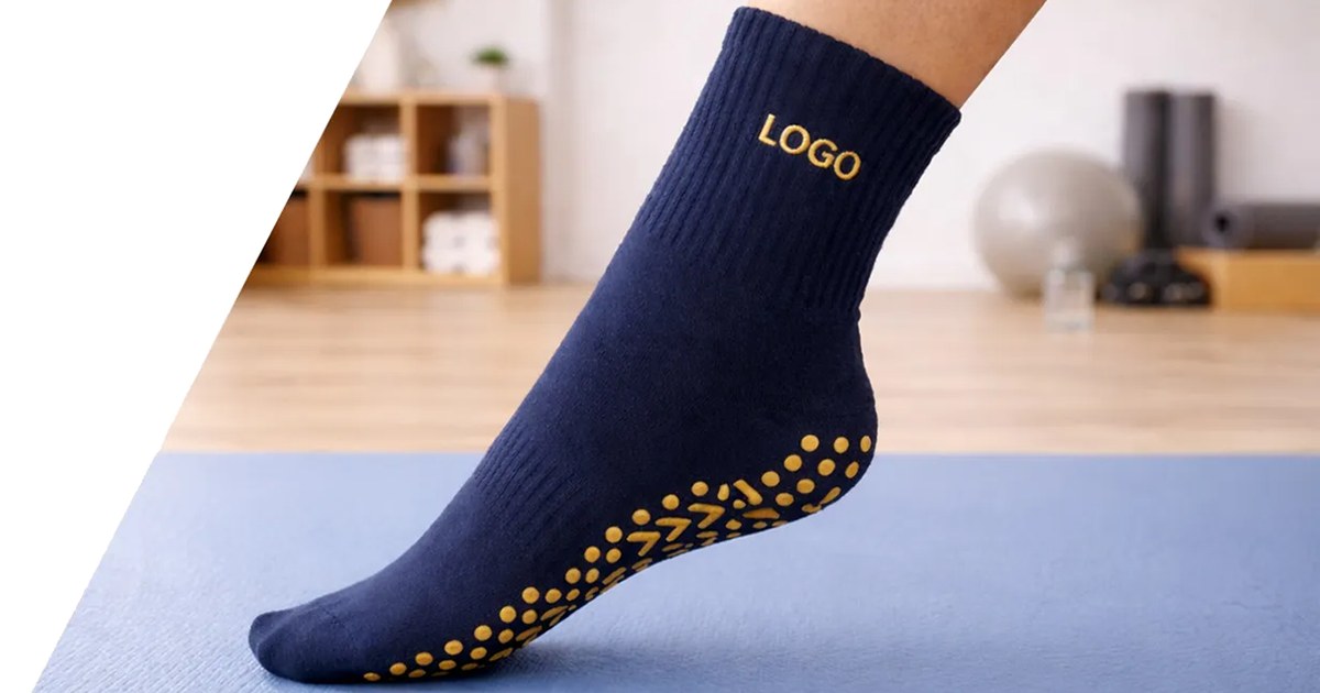 Navy custom pilates grip socks with yellow non-slip sole dots on a studio mat